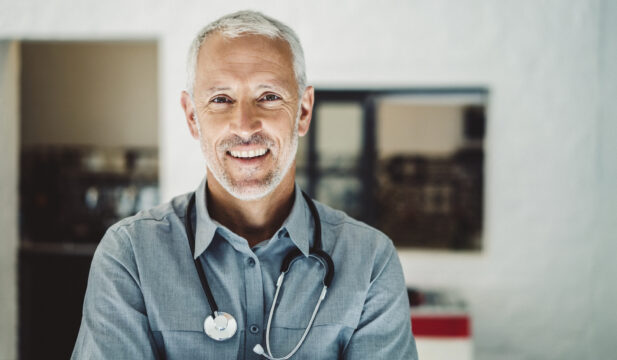 Doctor with stethoscope smiling in clinic