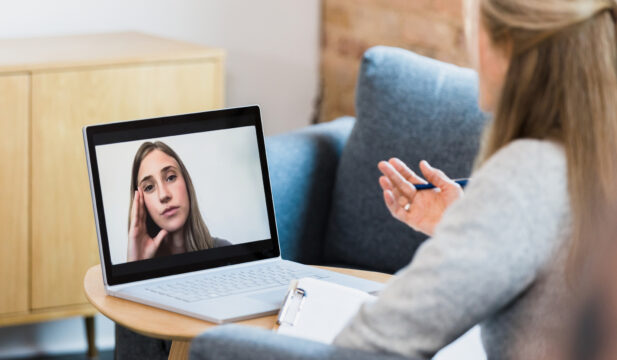 Female therapist meets with patient via video conferencing